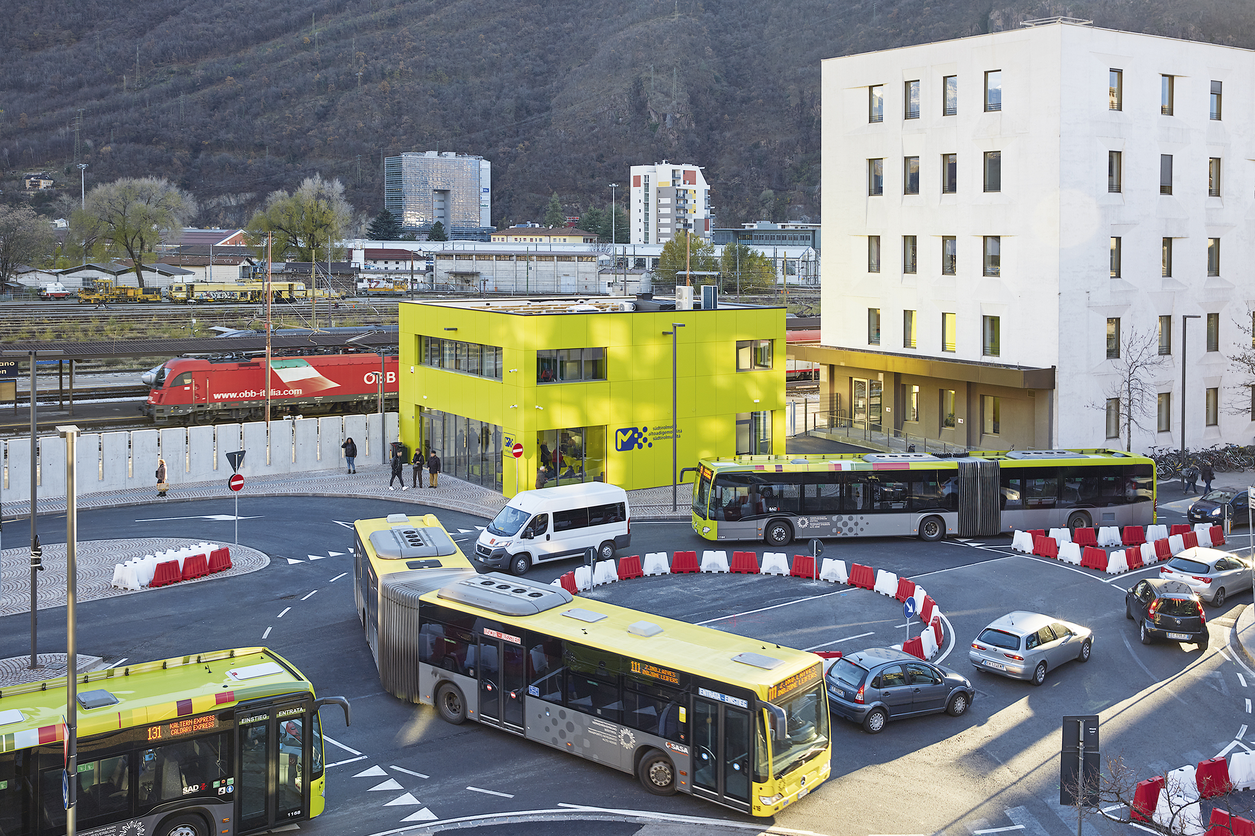 Due autobus alla rotonda davanti all'Infopoint dell'autostazione di Bolzano, visti dall'alto.